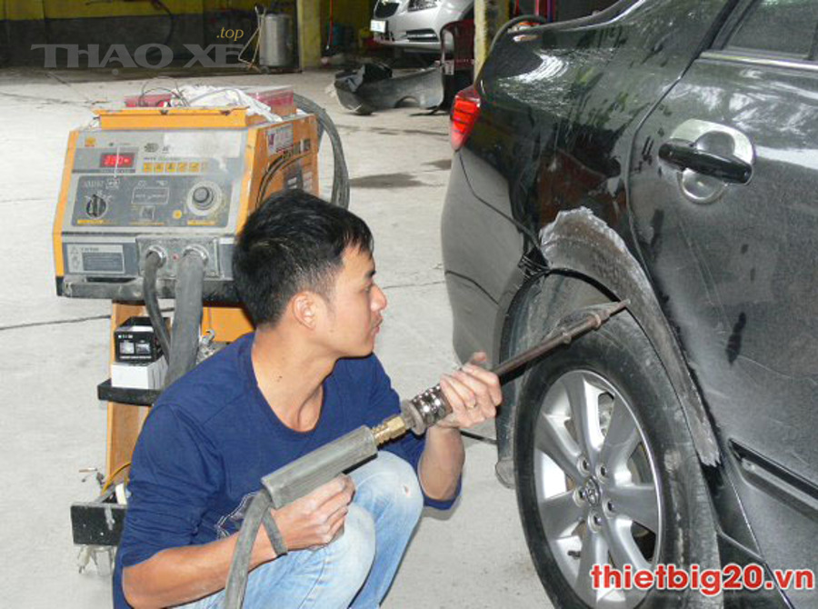 Kỹ thuật viên kiểm tra vùng móp thân vỏ ô tô trước khi sửa