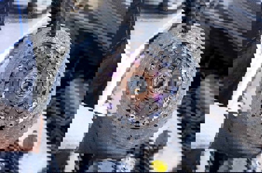 Kỹ thuật viên kiểm tra phụ tùng côn xe số sàn minh họa phân biệt lỗi côn và lỗi hộp số