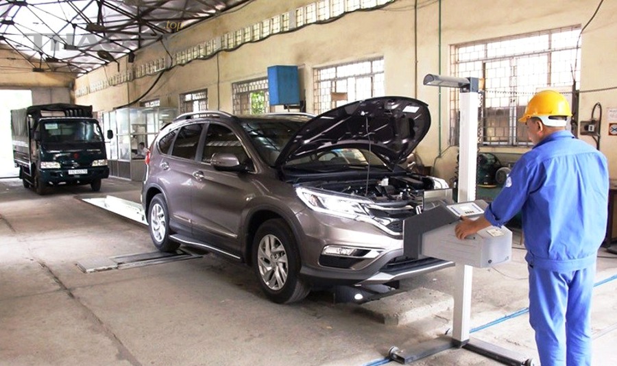 Kỹ thuật viên kiểm tra relay cầu chì và mạch điện đèn ô tô