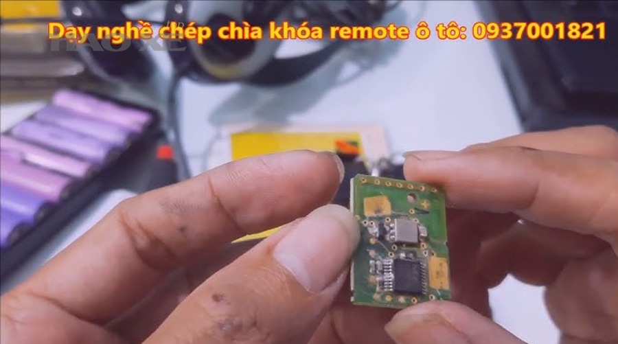Kỹ thuật viên bàn giao remote ô tô sau khi sửa và kiểm tra