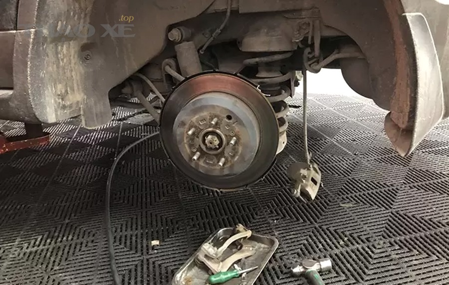 Kỹ thuật viên kiểm tra và sửa cụm phanh ô tô tại gara