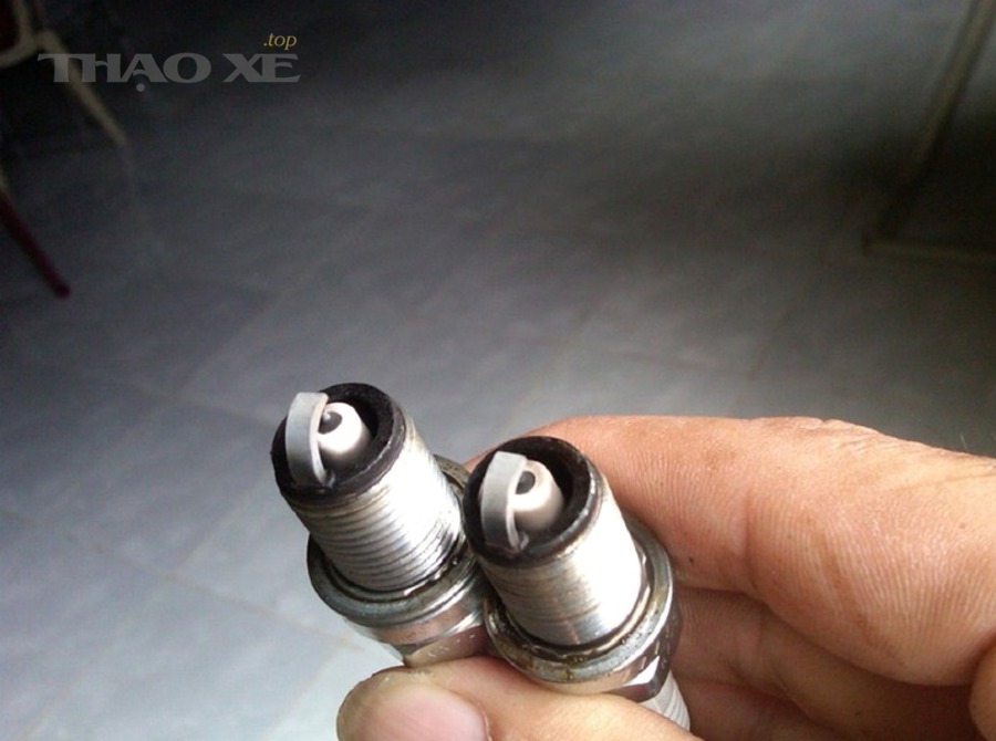 Kỹ thuật viên kiểm tra động cơ ô tô để xác định lỗi bugi hoặc bobin yếu khi nóng