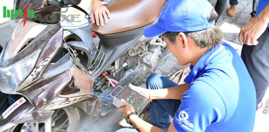 Kỹ thuật viên kiểm tra ắc quy xe máy để đảm bảo nguồn điện ổn định